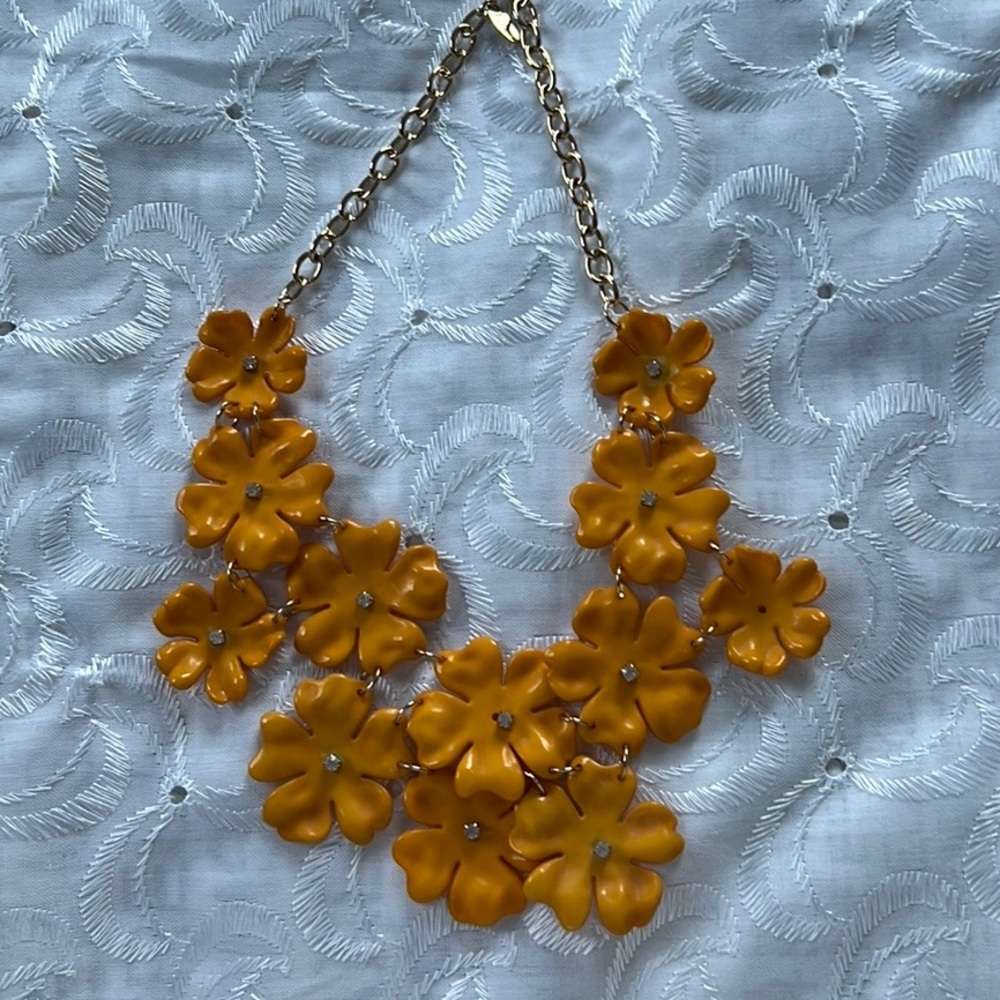 Floral necklace w/stud in the center of each flower. Mustard yellow. Plastic.